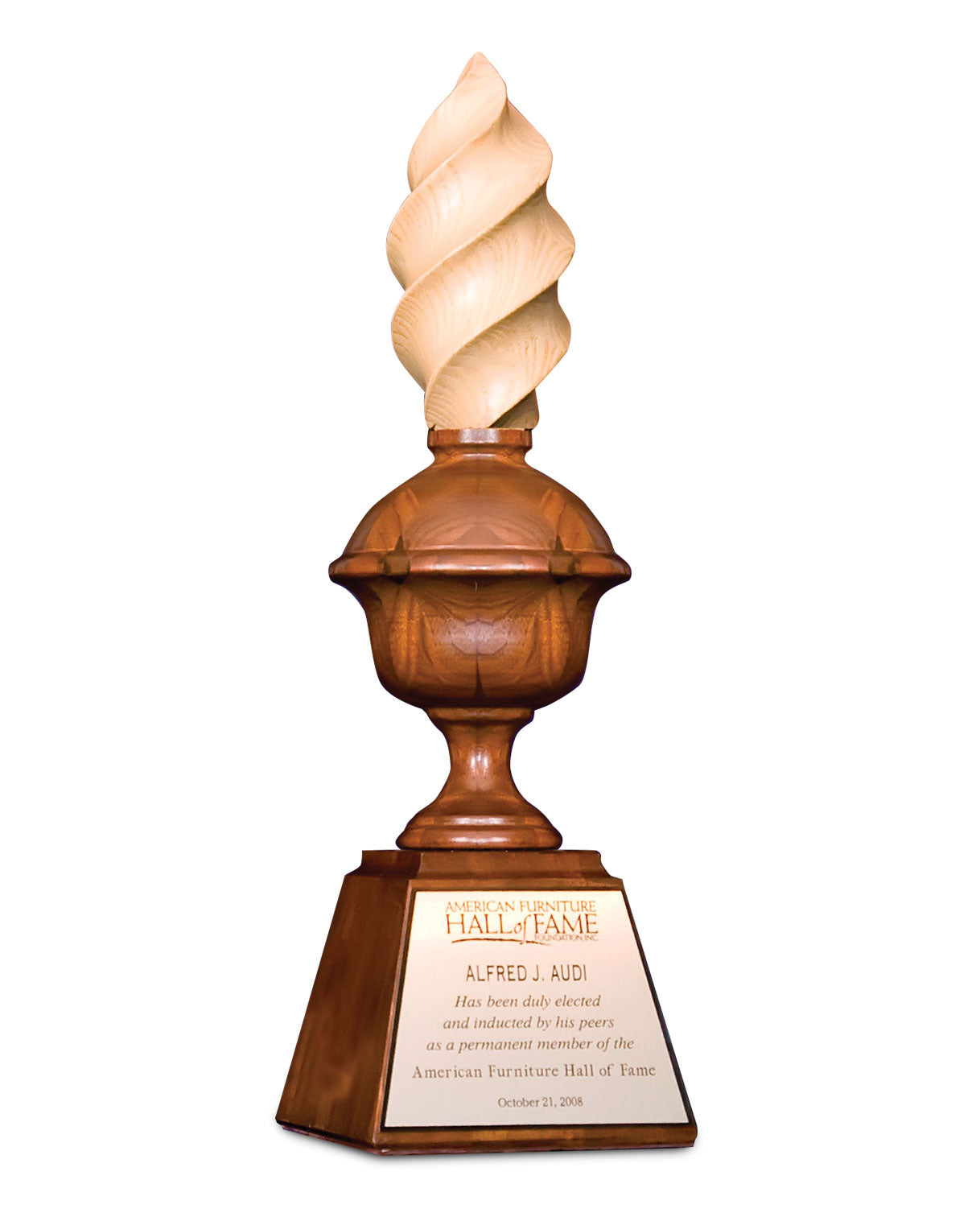 Wooden award trophy from the American Furniture Hall of Fame, featuring a spiral flame-shaped top. The plaque on the base honors Alfred J. Audi, stating his induction as a permanent member of the Hall of Fame on October 21, 2008.