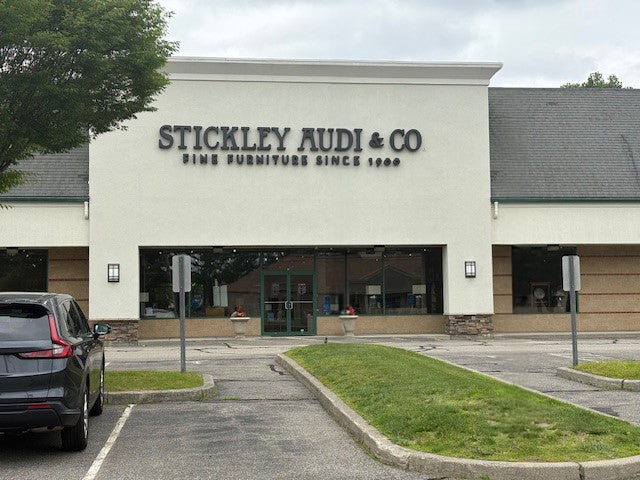 Exterior view of the Stickley Audi & Co. showroom in Brookfield, Connecticut, with the storefront sign reading 'Fine Furniture Since 1900' and a mostly empty parking lot in front.