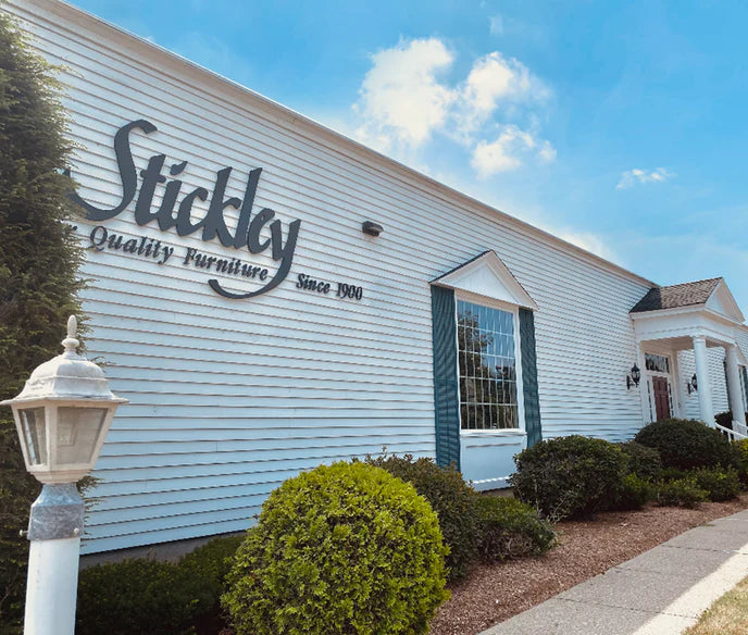 Exterior of Stickley Furniture showroom in Enfield, Connecticut, featuring white siding, green shutters, and the Stickley logo with “Quality Furniture Since 1900.”