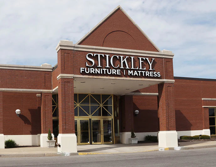 Exterior view of Stickley Furniture | Mattress store in Fayetteville, NY, featuring a red brick facade and prominent white signage.