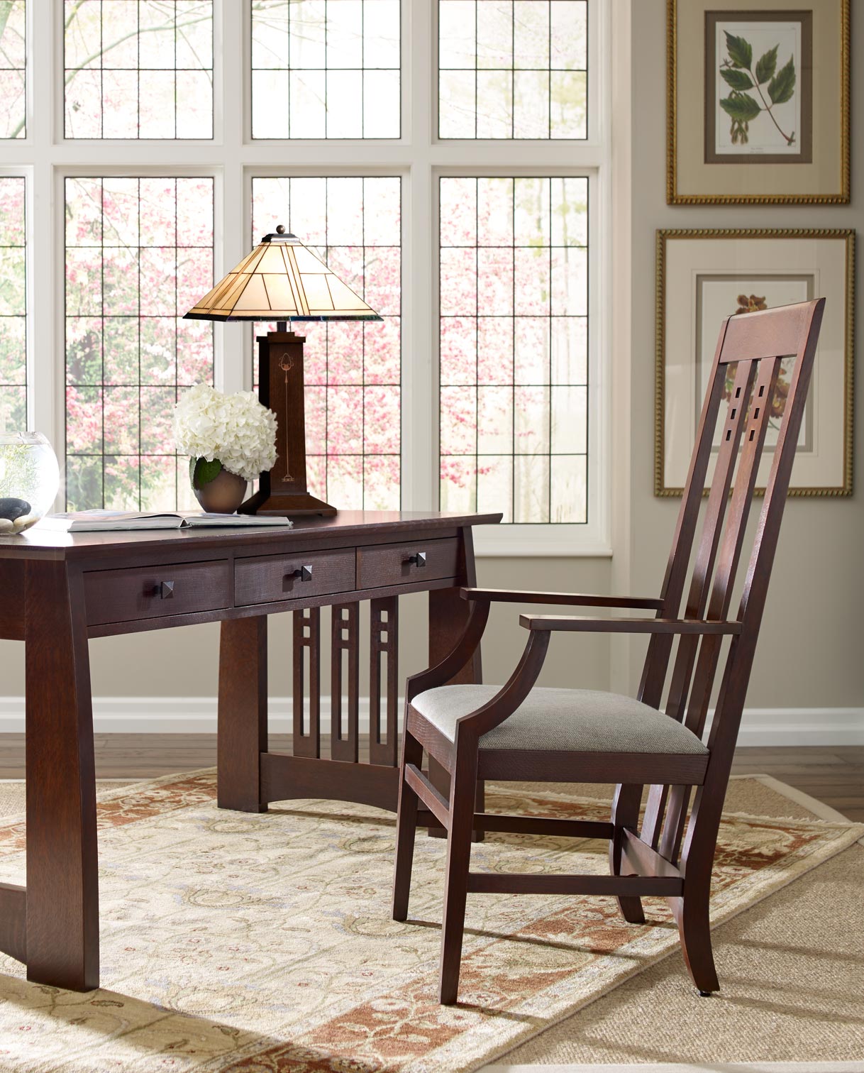 Lifestyle of Highlands Writing Desk with a Highlands Arm Chair next to it in front of a large window