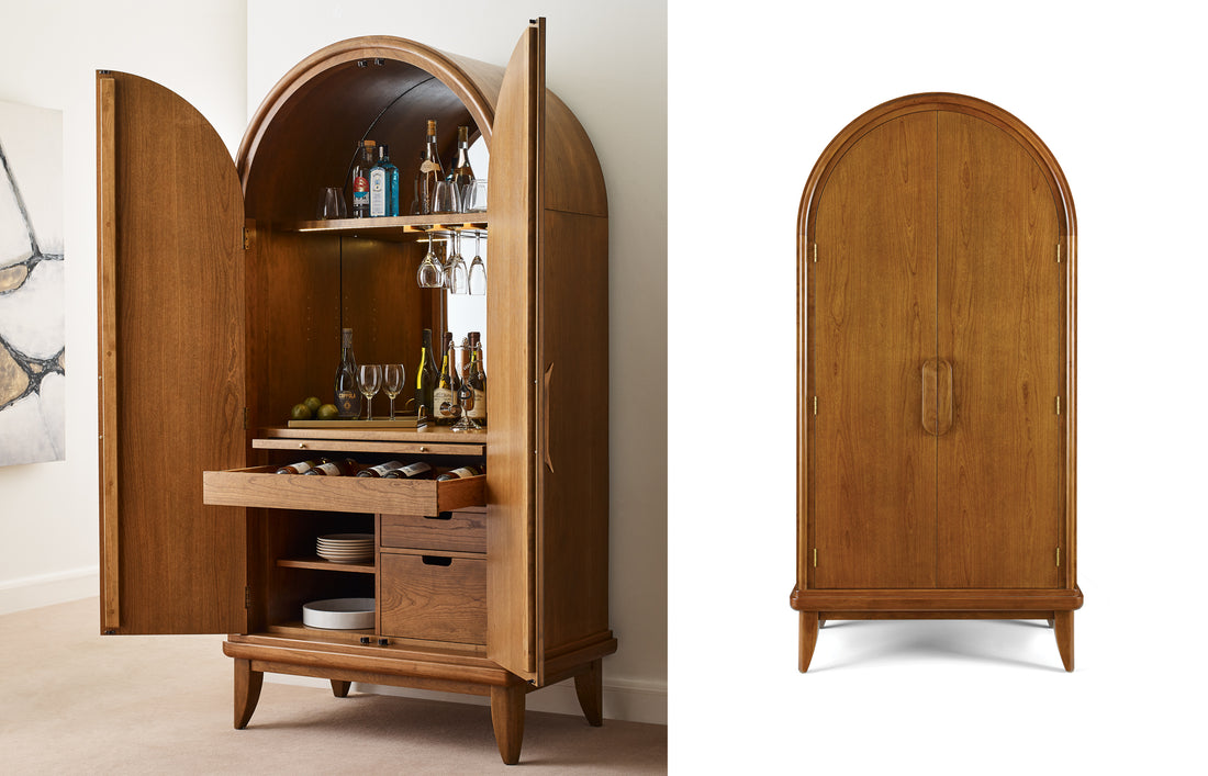 The Martine Arced Bar Cabinet shown open and closed, featuring a gracefully rounded top, built-in glassware storage, a mirrored back panel, wine bottle drawers, and adjustable shelving, all crafted in warm cherry wood with sculptural handles that emphasize Martine’s soft modern aesthetic.