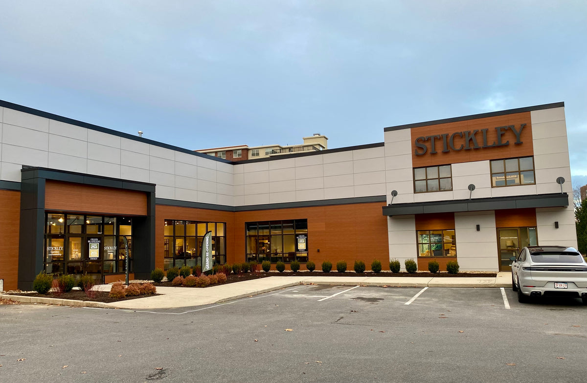 Exterior view of the Stickley showroom in Enfield, Massachusetts, featuring modern architectural design with large windows, clean lines, and prominent Stickley signage—highlighting a luxury furniture retail destination in New England.