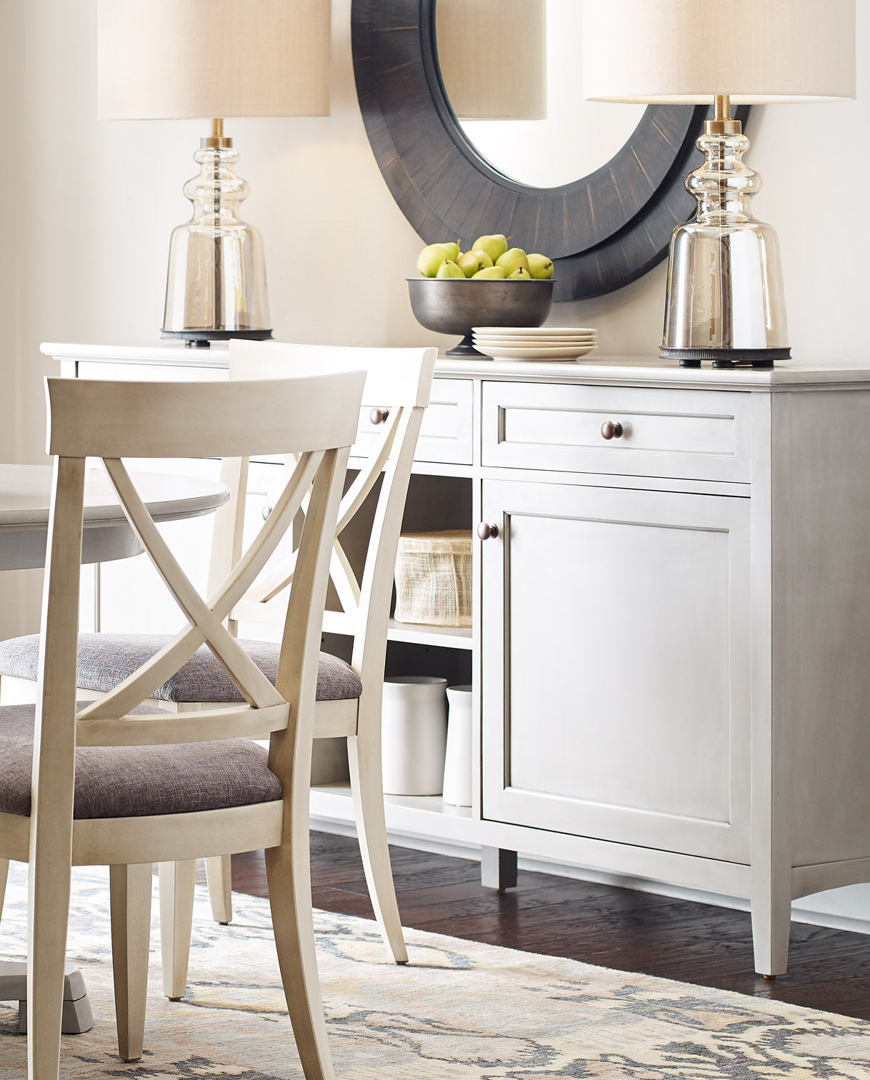 Lifestyle of a White Revere Large Server with a bowl of green apples on top of it and a black circular mirror hung above it