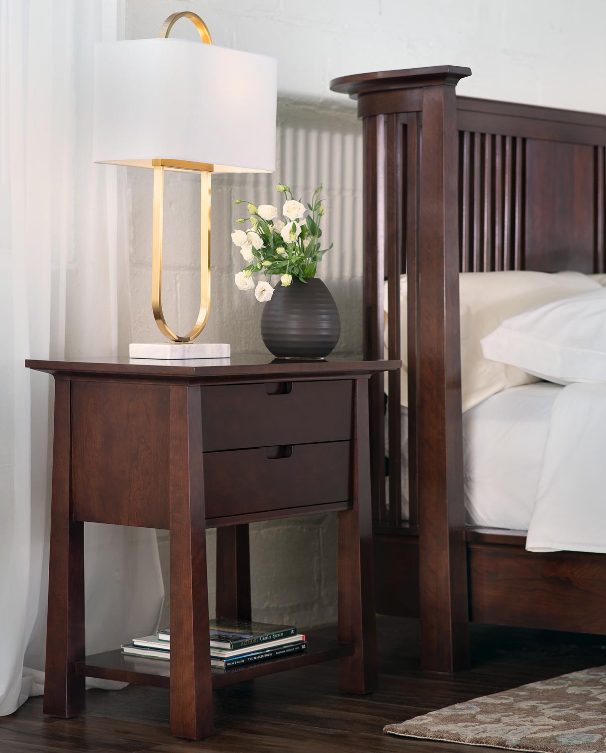 Lifestyle of a Park Slope Platform Bed with an open nightstand next to it that has a a lamp and small vase with flowers in it on top.