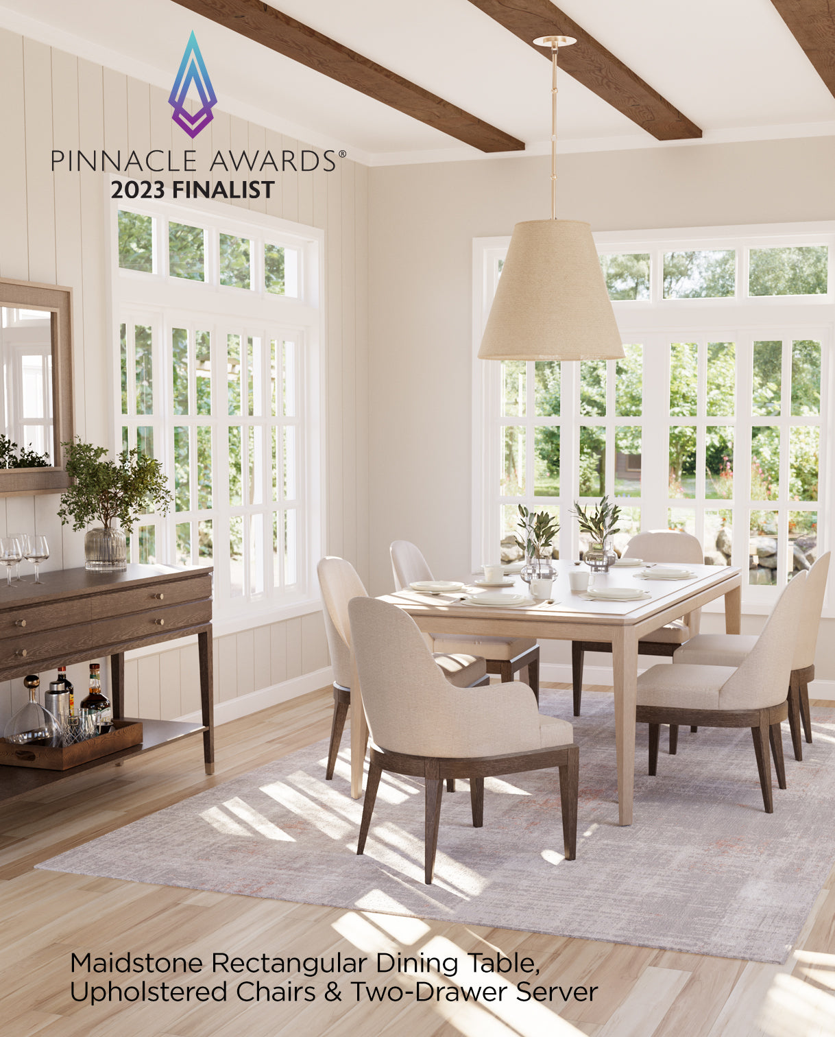 Bright and elegant dining room featuring the Pinnacle Awards® 2023 Finalist Maidstone Collection, including a rectangular dining table, upholstered dining chairs with wood legs, and a two-drawer server with open shelving. The space is styled with soft neutral tones, a large pendant light, and expansive windows that bring in natural light.