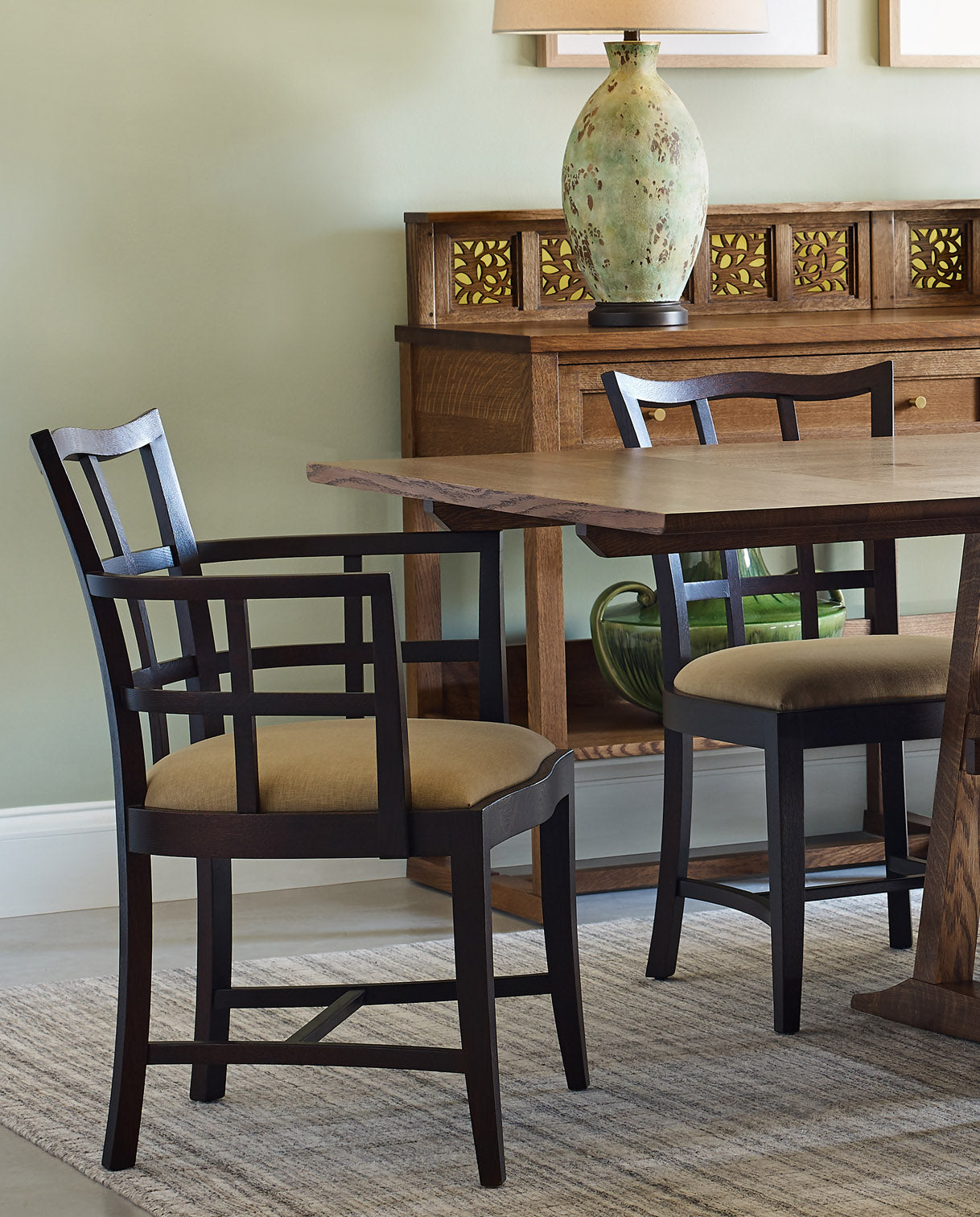 Lifestyle of Surrey Hills Trestle Table showcasing an arm chair and side chair, with a Surrey Hills server with gallery in the background