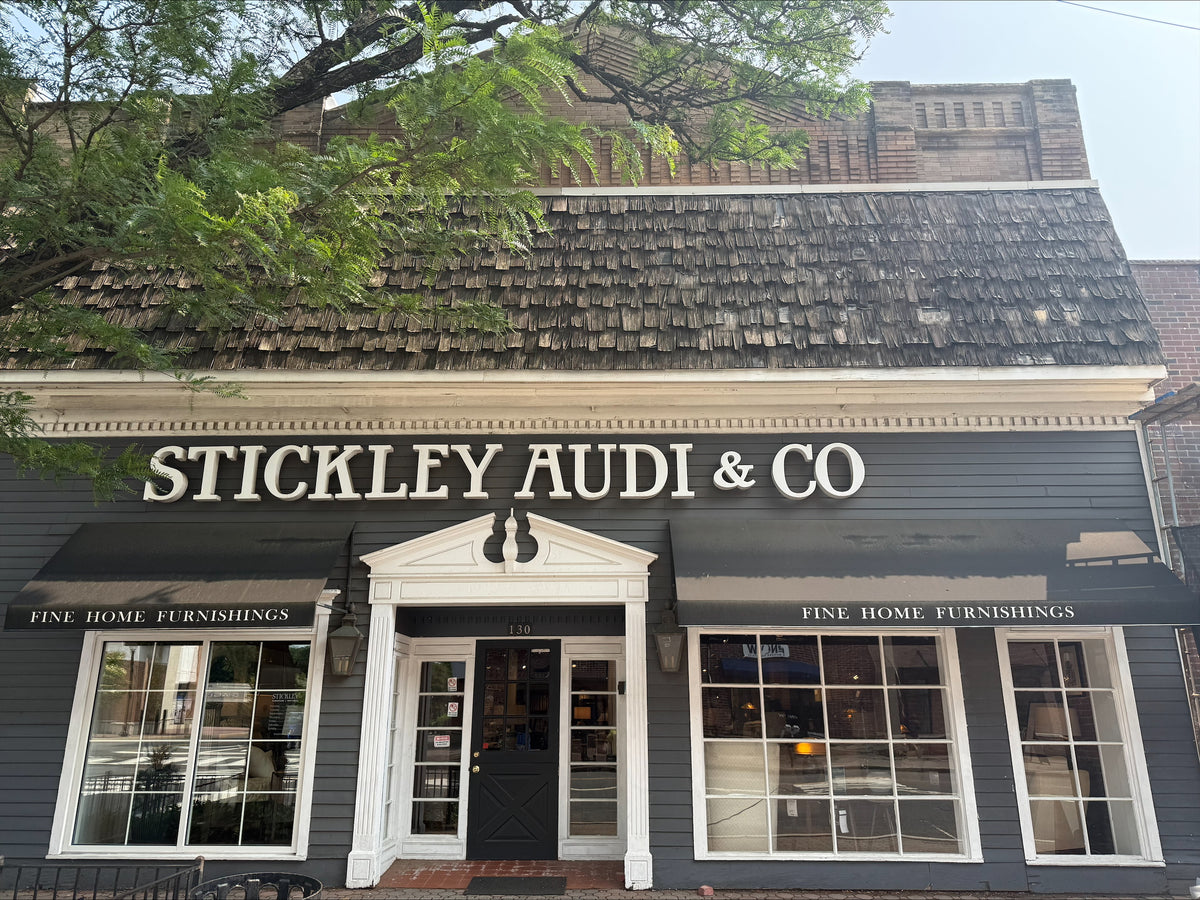 Exterior view of the Stickley Audi & Co. showroom in Somerville, NJ, featuring a charming storefront with navy blue siding, large display windows, and classic black awnings—representing timeless style and fine furniture craftsmanship.